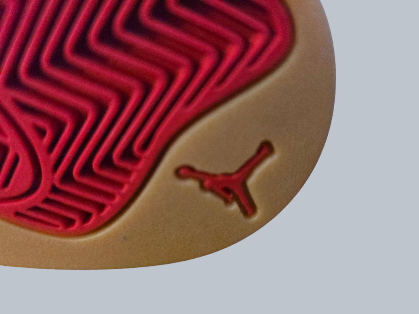 Zbliżenie na gumową podeszwę butów Latające Wieszaki Jordan z czerwonym logo Jumpman i bieżnikiem