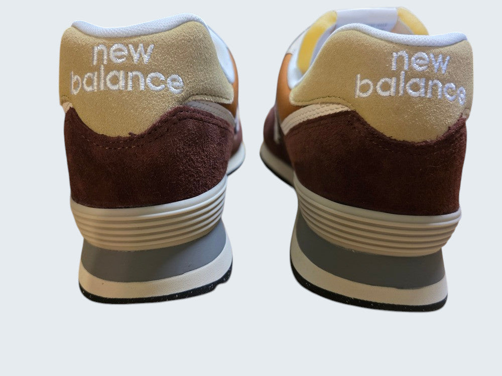 Tylny widok butów sportowych New Balance w kolorach brązowym, beżowym i szarym od Latające Wieszaki