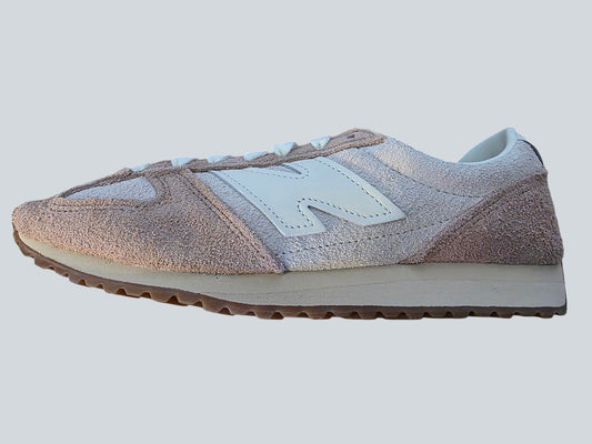 Damskie sneakersy Latające Wieszaki New Balance z zamszu w odcieniach różu i beżu z charakterystycznym logo na boku.