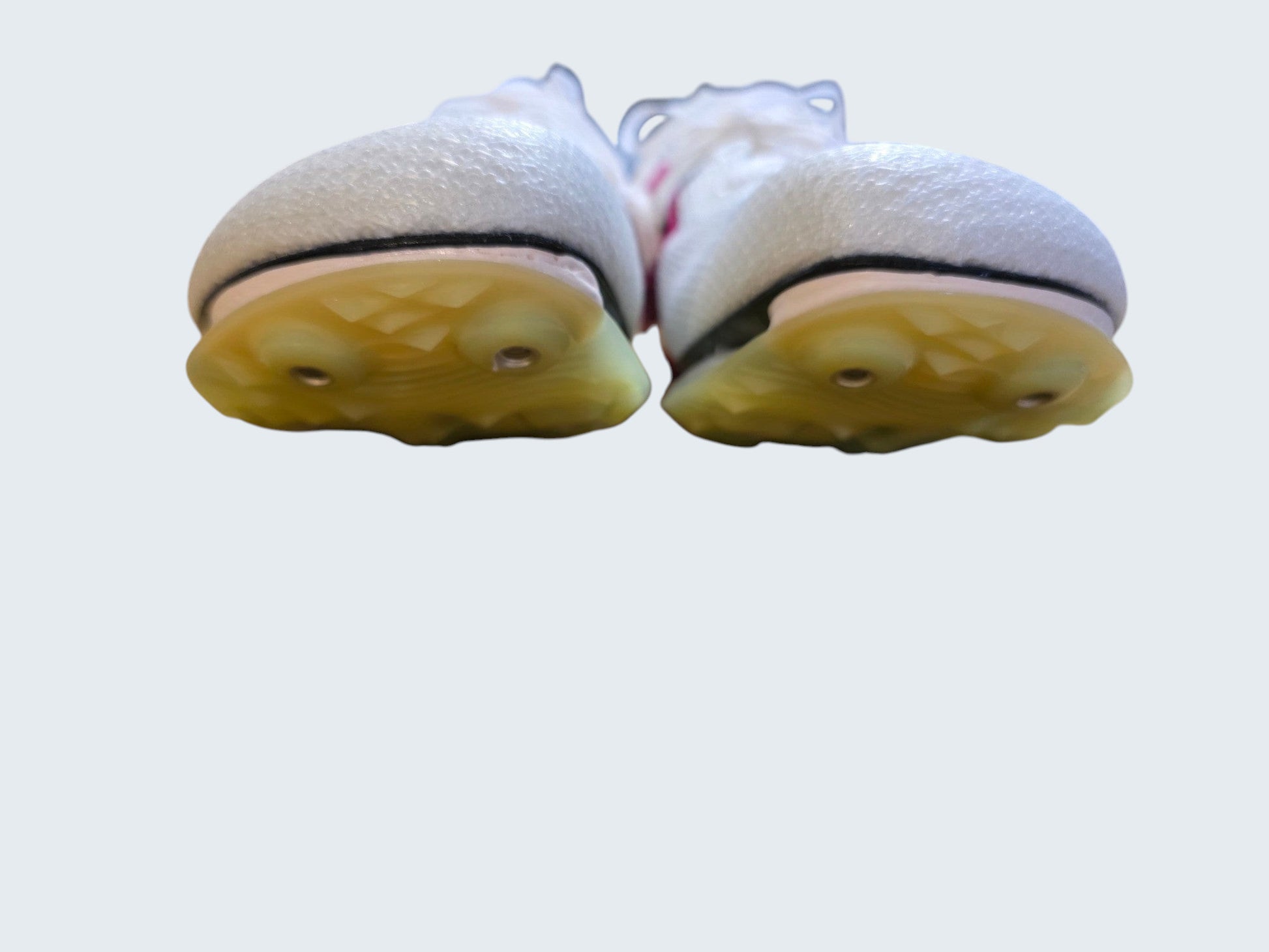 Białe kolce lekkoatletyczne Nike Air Zoom Victory z różowymi akcentami od Latające Wieszaki na drewnianym blacie