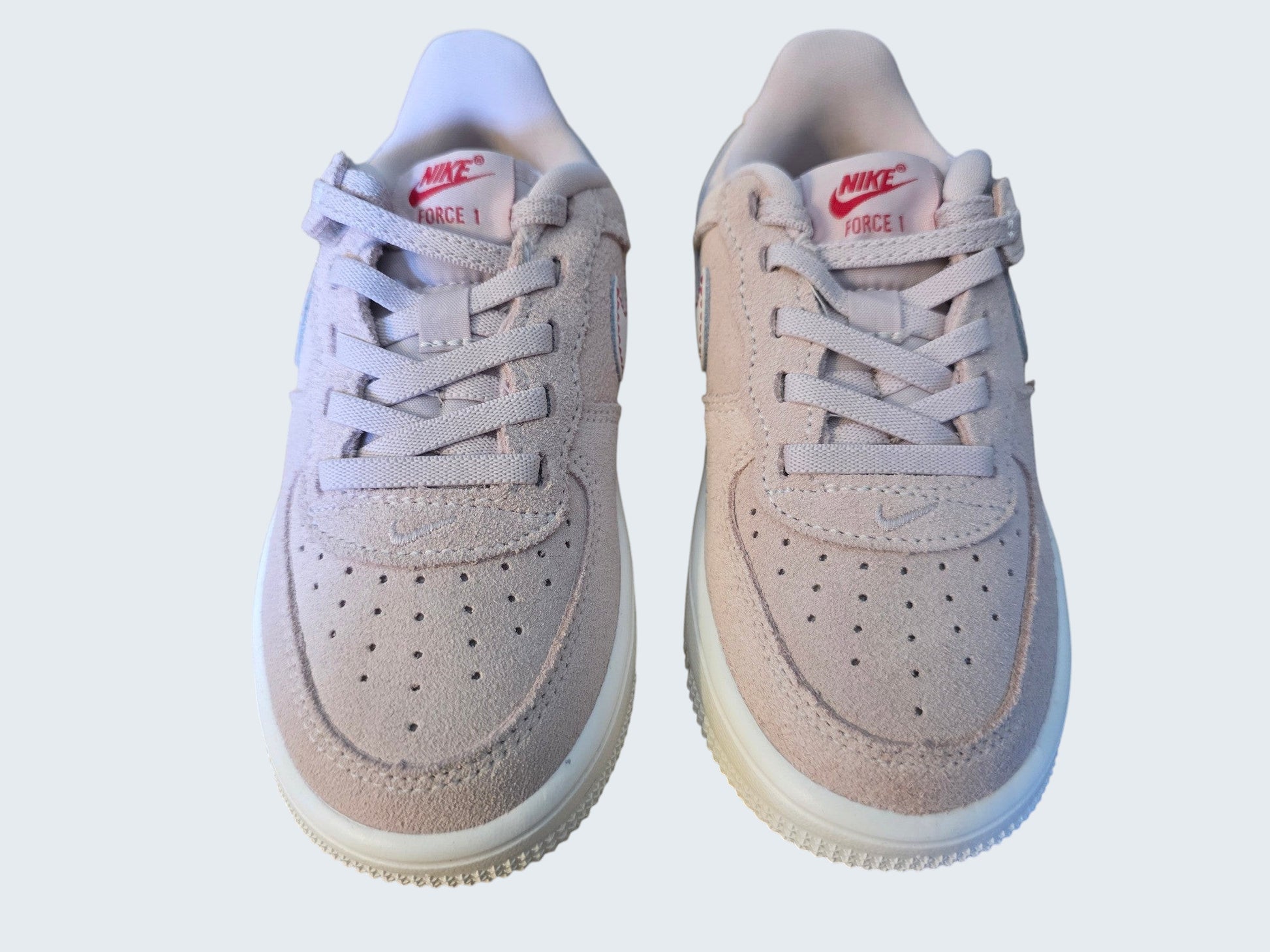 Dziecięce buty sportowe Nike Force 1 od Latające Wieszaki z różowego zamszu z czerwonym logo i gumową podeszwą