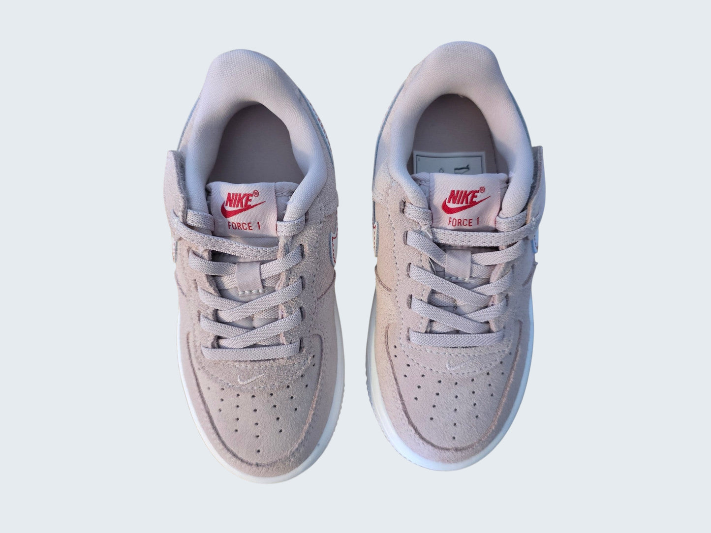 Dziecięce buty sportowe Nike Force 1 od Latające Wieszaki w pastelowym różu z zamszu z czerwonym logo i rzepem