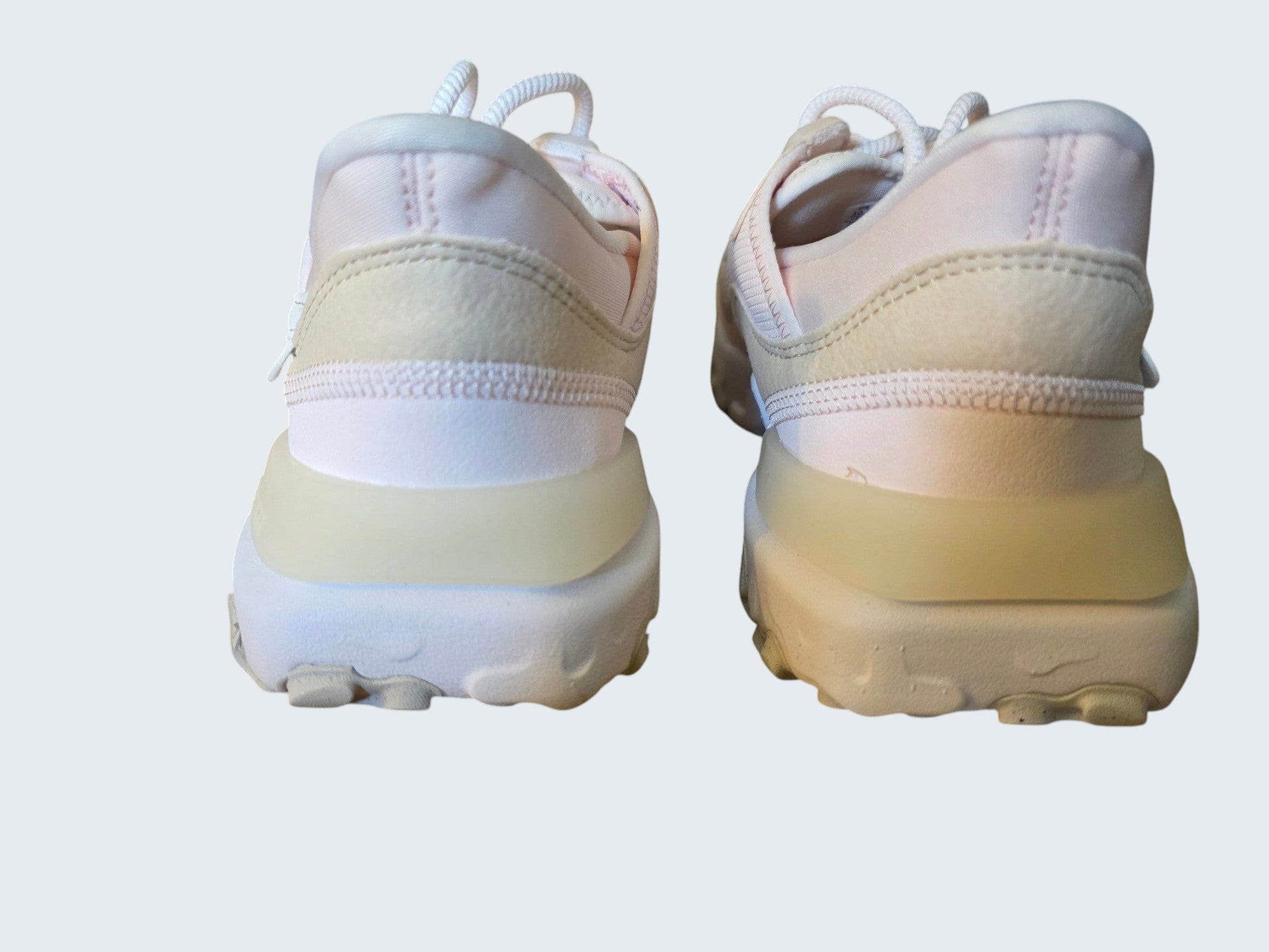 Widok z tyłu damskich butów sportowych Nike React Vision w pastelowych odcieniach różu i beżu od Latające Wieszaki